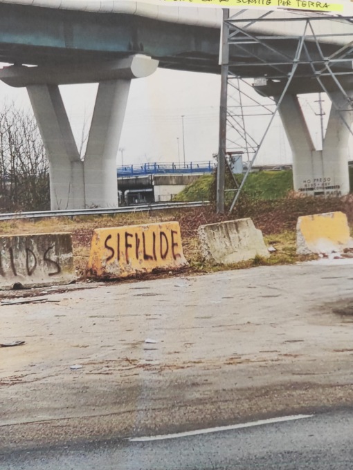Strada tappezzata di scritte contro la prostituta