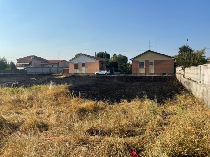 Campo in fiamme vicino alle case