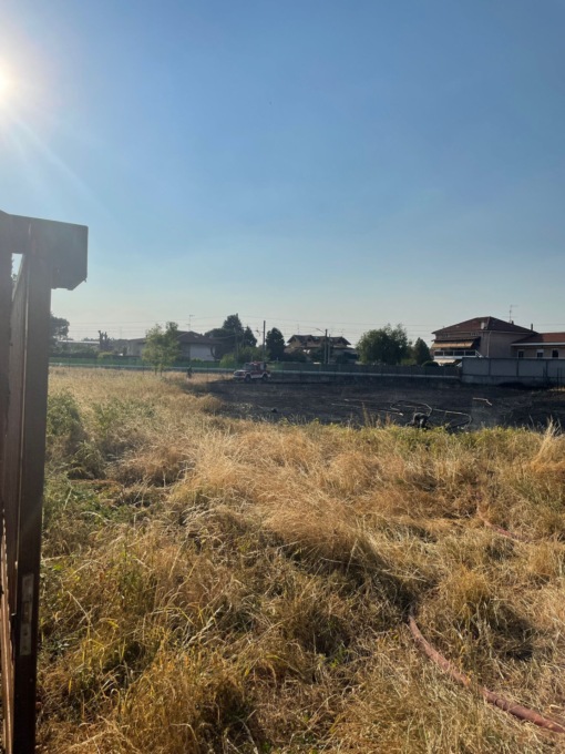 Campo in fiamme vicino alle case
