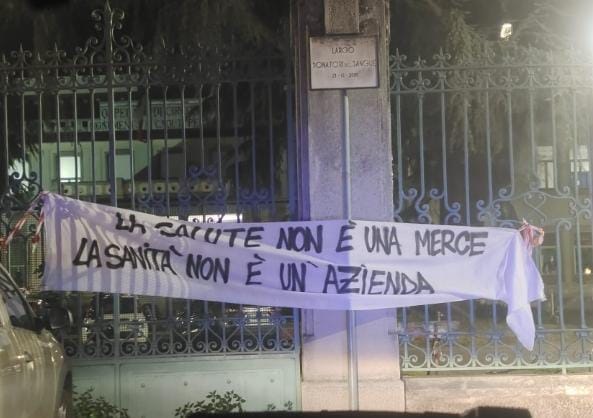 “La salute non è una merce, la sanità non è una azienda” Striscione appeso sulla cancellata dell’ospedale