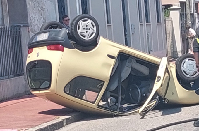 Finisce contro un’auto in sosta e si ribalta