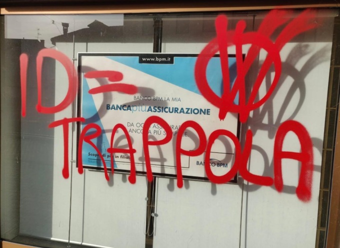 Scritte contro pagamenti elettronici e Identità Digitale sulle vetrine di un banca