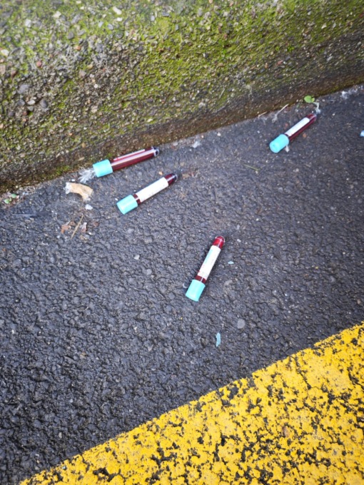 Provette di sangue e aghi abbandonati per strada