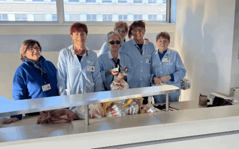 Un fiocco rosso e un volantino con i numeri antiviolenza distribuiti in ospedale dalle volontarie Acvo